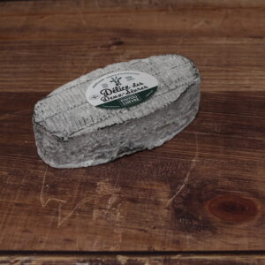 Photo d'un Délice des Deux-Sèvres, vu en plongée. Fromage oval, avec une croûte cendrée, légèrement frippée.