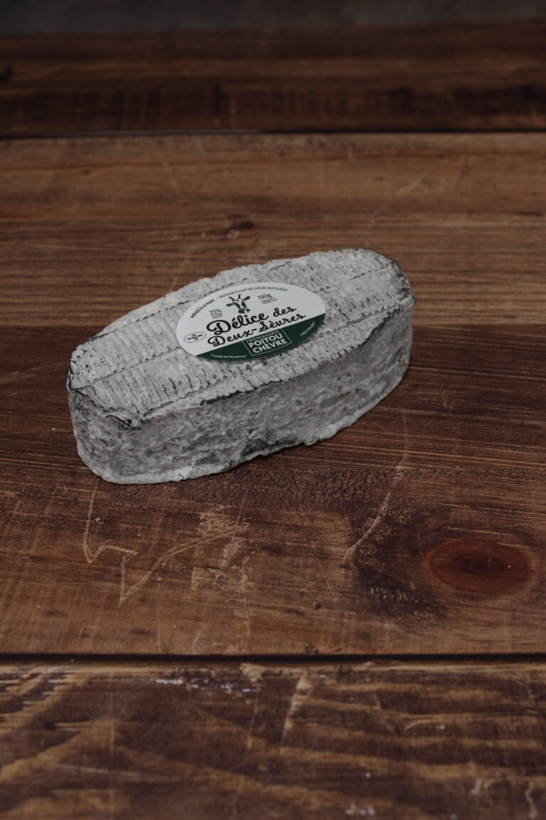 Photo d'un Délice des Deux-Sèvres, vu en plongée. Fromage oval, avec une croûte cendrée, légèrement frippée.