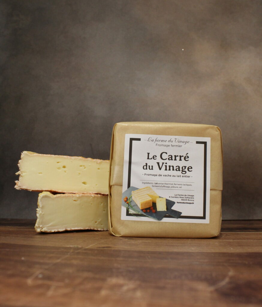 Photo de face de Carré du Vinage. A droite, debout un fromage entier et emballé. A gauche, un fromage dont les 2 moitiés sont empillées.
